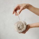 person holding brown yarn ball